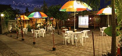 Garden cafe with umbrellas at Patria Garden Hotel at night